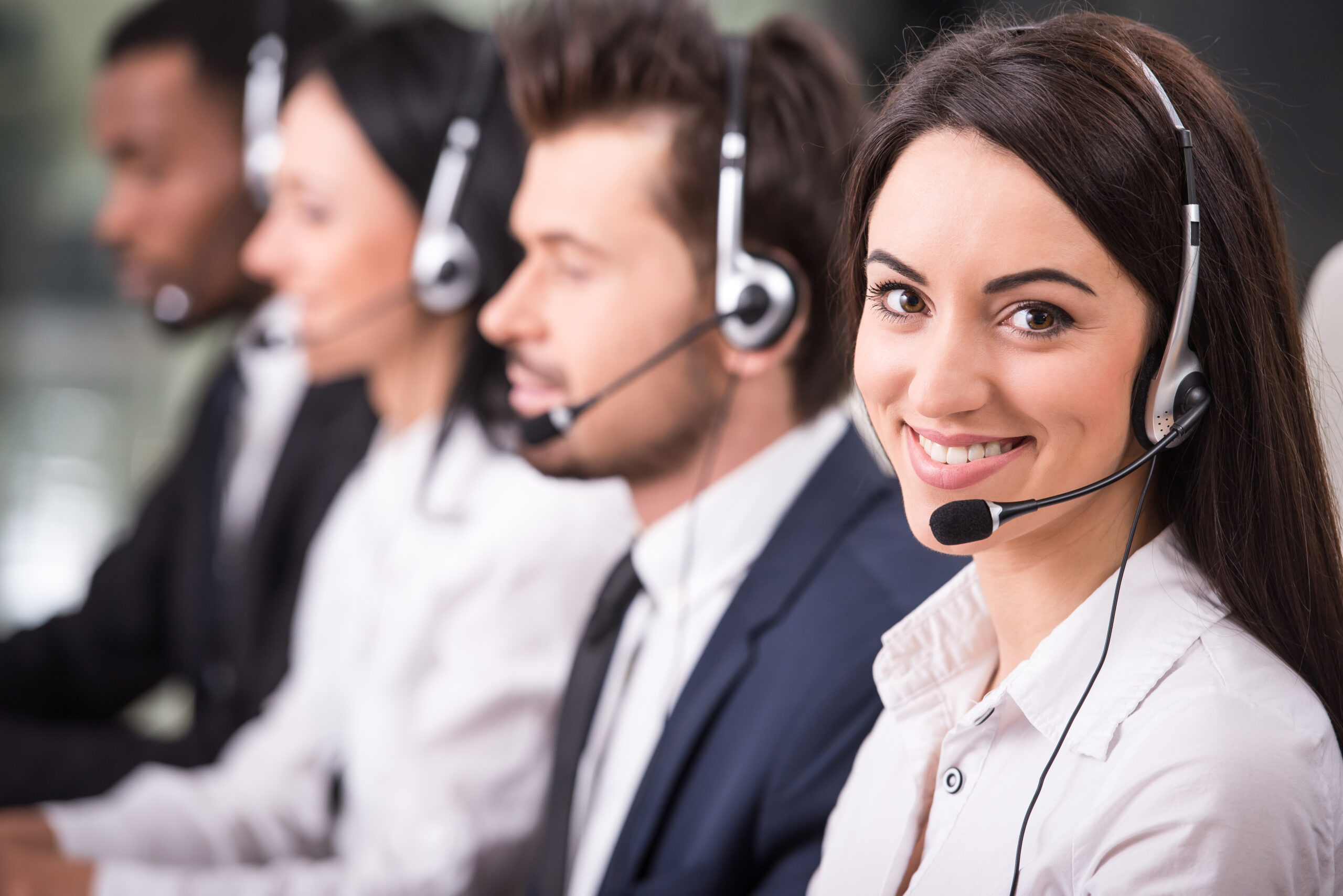 Employees are smiling and working on computers.